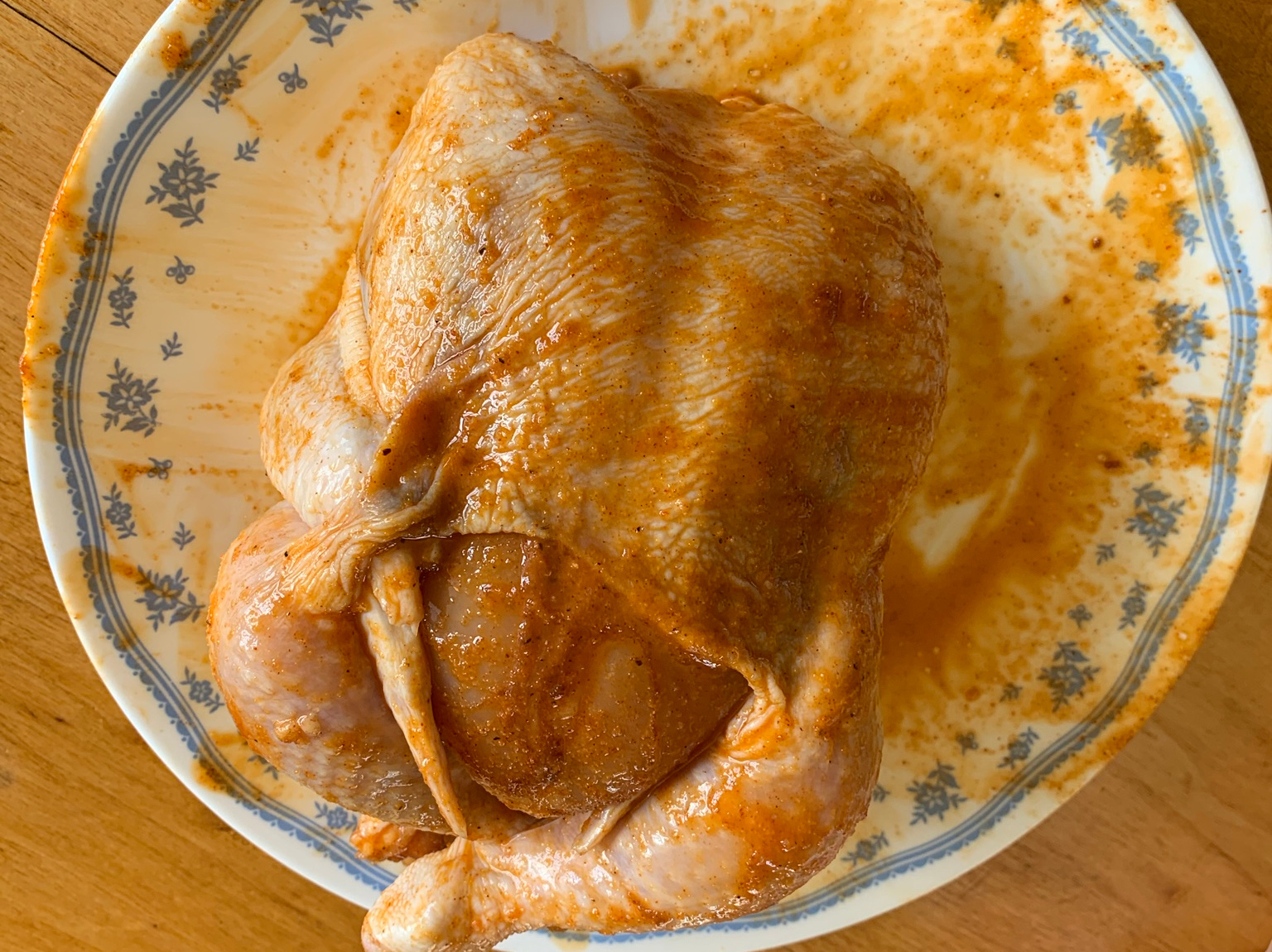 A chicken, rubbed with my homemade rub, ready for cooking. It's quite yellow, probably from the paprika.