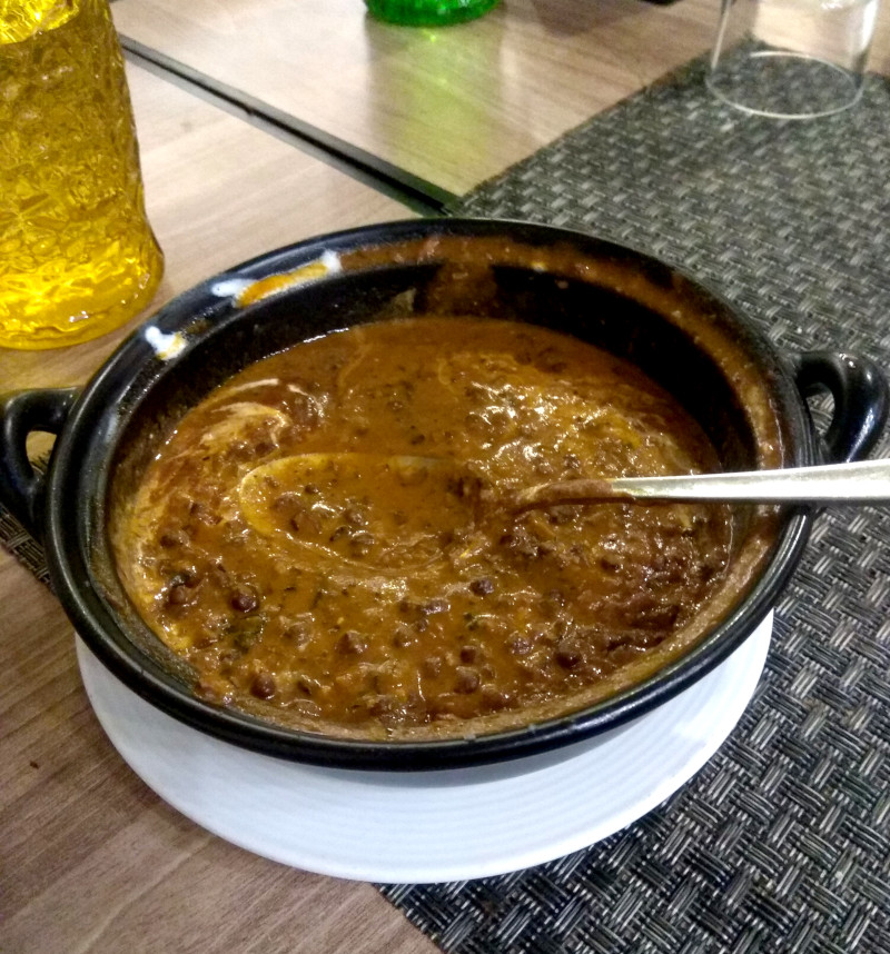 A dark, brown-green daal makhani, with swirls of cream visible.