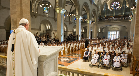 Pope Francis giving mass in front of a large congregation