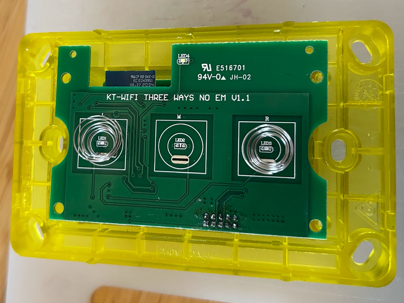 The disassembled switch: a yellow plastic case with a green circuit board